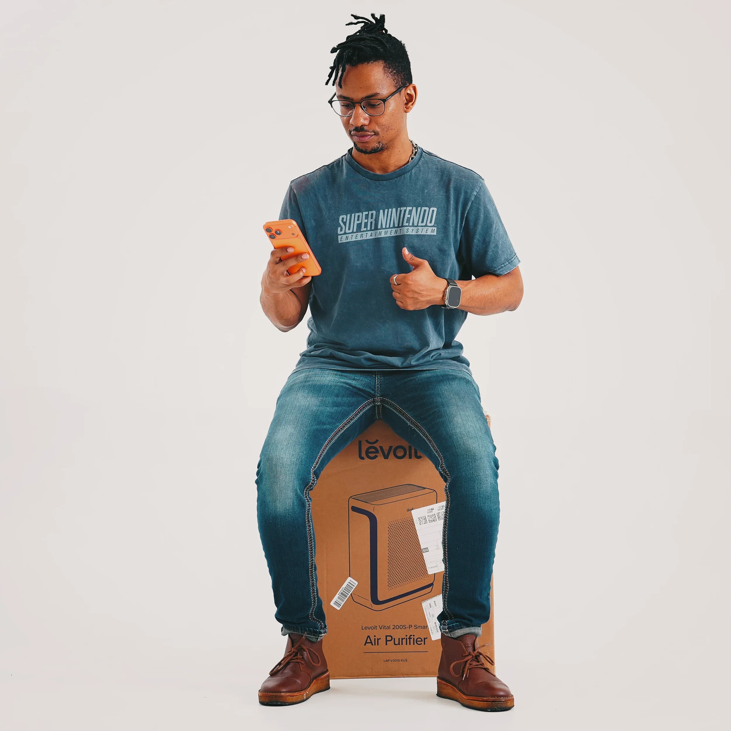 Studio portrait — subject perched on a Levoit air-purifier box